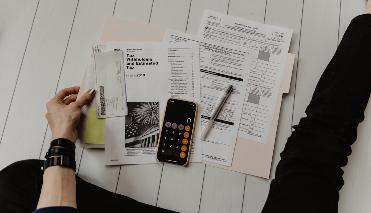 Finance documents and planning materials on a wood surface