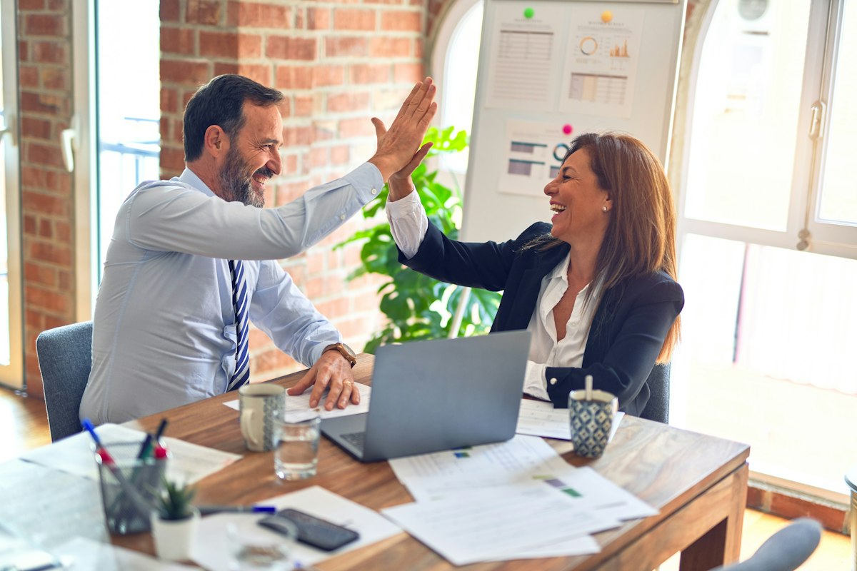 Professionals collaborating across a wooden conference table